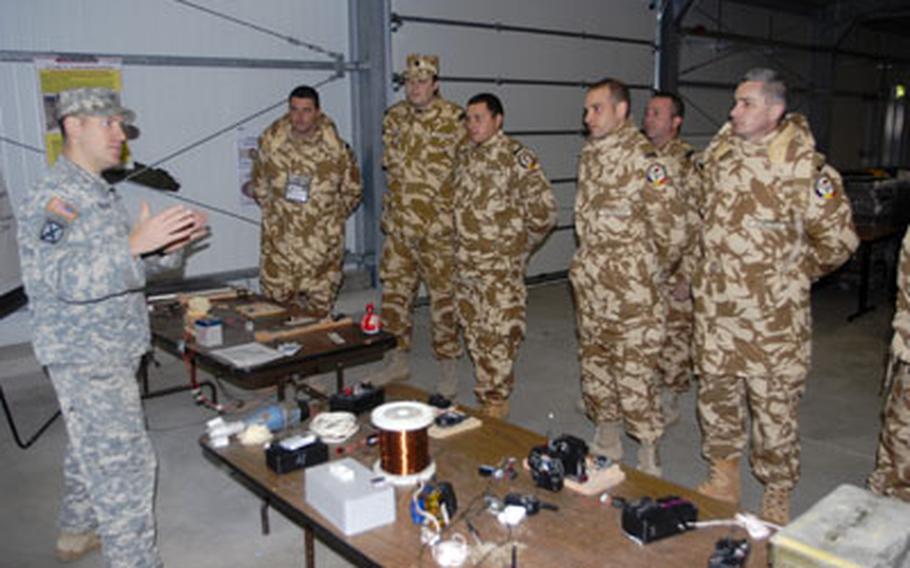 Sgt. 1st Class Steven Barker, left, an observer controller with the Joint Multinational Readiness Center’s Raptor Team, trains Romanian soldiers on how to deal with the improvised-explosive device threat in Afghanistan.
