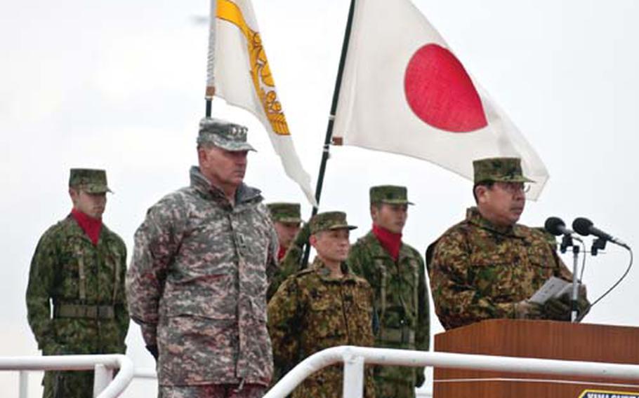 Lt. Gen. Takeshi Sakai, commanding general, Northern Army, Japan Ground Self-Defense Force, addresses the troops while Lt. Gen. Benjamin Mixon, commander of U.S. Army Pacific, looks on during the opening ceremony for this year’s Yama Sakura exercise. More than 1,500 U.S. military personnel and nearly 3,500 members of the JGSDF are participating.