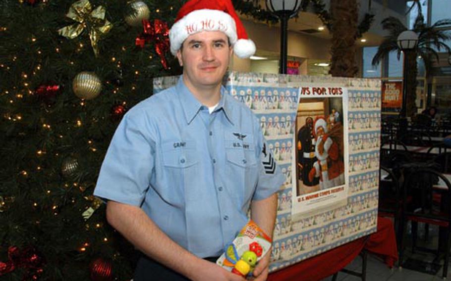 Petty Officer 1st Class Nathan Grant visits a Toys for Tots collection box Friday at Naval Air Facility Atsugi, Japan, where he recently donated thousands of dollars worth of toys to needy children.