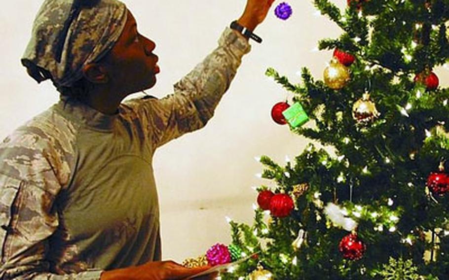 Air Force Tech. Sgt. Kimberly Waters hangs ornaments on a Christmas tree at the Chaldean Catholic Church in Basra, Iraq, on Dec. 5. Waters was to redeploy to the U.S. a few days later, but most of her colleagues will spend the holidays at their muddy base near the city’s airport.