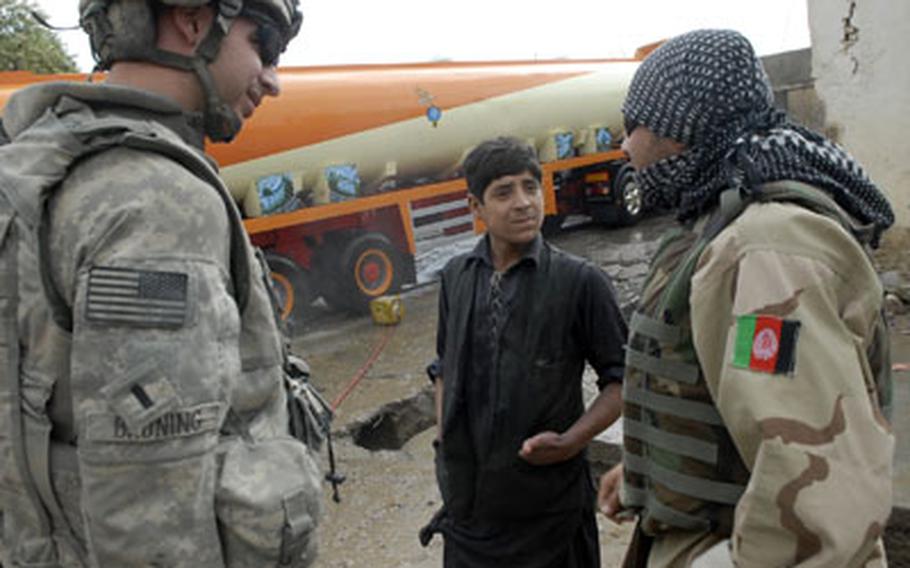 First Lt. Spenser Bruning, left, talks to a boy in Kandahar, Afghanistan, after he doused an armored truck in Bruning’s convoy with water. Bruning and his fellow soldiers in the 4th Engineer Battalion were moved from Iraq to Afghanistan midtour and have had to make many adjustments.