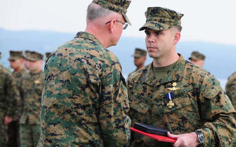 Gunnery Sgt. John Mosser, right, is congratulated by Gen. James B. Laster, the commanding general of 3rd Marine Division, after receiving the Navy Cross on Friday. Mosser was awarded the medal for actions when he and his reconnaissance team were ambushed and pinned down by heavy small-arms fire in June in Afghanistan. The Navy Cross is the second highest military award for valor.