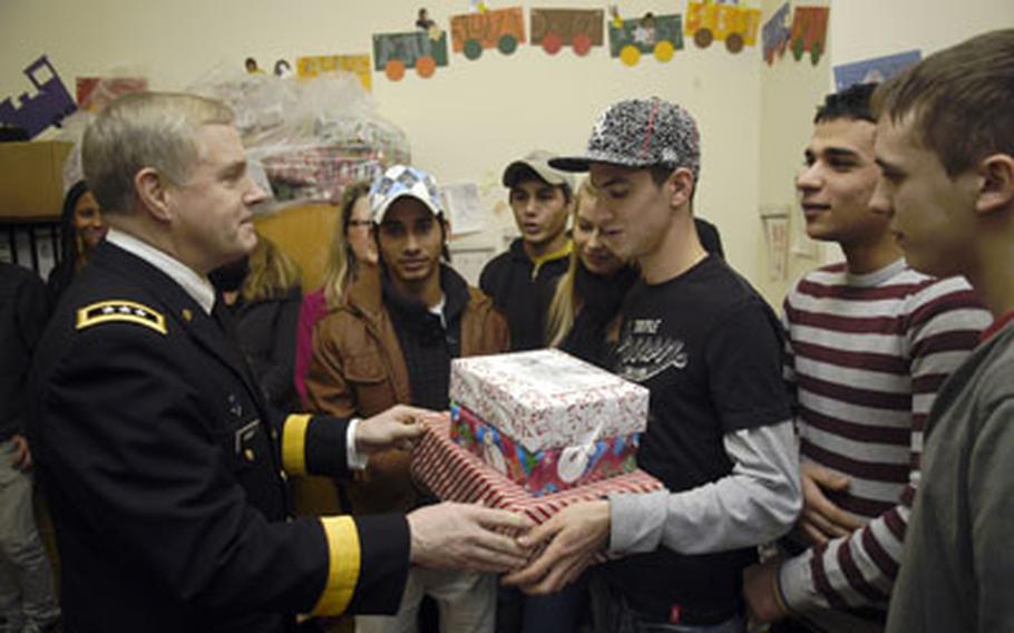 Lt. Gen. John D. Gardner, deputy commander of U.S. European Command, delivers gifts to Stuttgart, Germany, area teenagers. EUCOM staff collected hundreds of presents to support a local orphanage and Stuttgart’s youth services department.