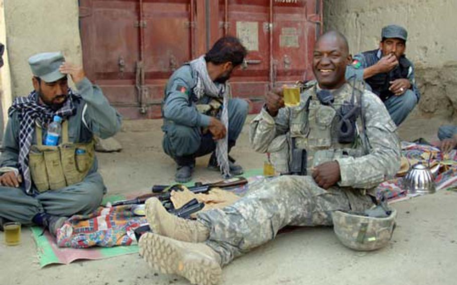 U.S Army Sgt. 1st Class David Banks, from Alpha Company, 2nd Battalion, 508th Parachute Infantry Regiment, drinks tea with Afghan National police during a cordon and search of Pana, Afghanistan, June 9, 2007.