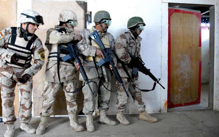 A squad of Iraqi soldiers clears a building during an exercise at the Besmaya Training Center. Housed at a former Republican Guard complex, the center includes 26 weapons ranges, M1A1 tank training and a bomb disposal school. U.S. advisers as a model, but questions remain about the center&#39;s future as the U.S. pulls back.