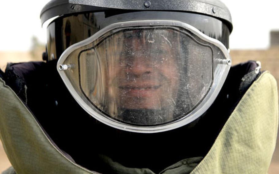 Mundir Mohammed, a bomb disposal specialist from the 11th Iraqi Army Division, smiles from within an armored suit during training at the Besmaya bomb disposal school, which includes Iraq&#39;s only facility to repair damaged bomb-disposal robots. Mohammed says his mother wishes he had a different job.