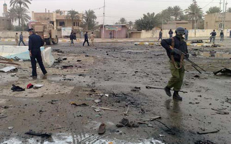 Iraqi security forces walk the site of a bombing in Ramadi on Wednesday. A pair of suicide bombers killed 24 people in Ramadi and badly injured the governor of Anbar province, where the alliance between Sunni tribes and the U.S. military first took hold.