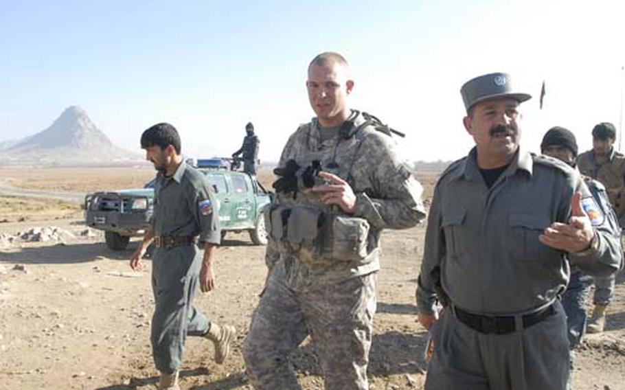 U.S. Army Capt. Mike Thurman, middle, walks with Kandahar chief of security Col. Fazal “Shirzad” Ahmad on a visit to a checkpoint in the Arghandab Valley near Kandahar city.