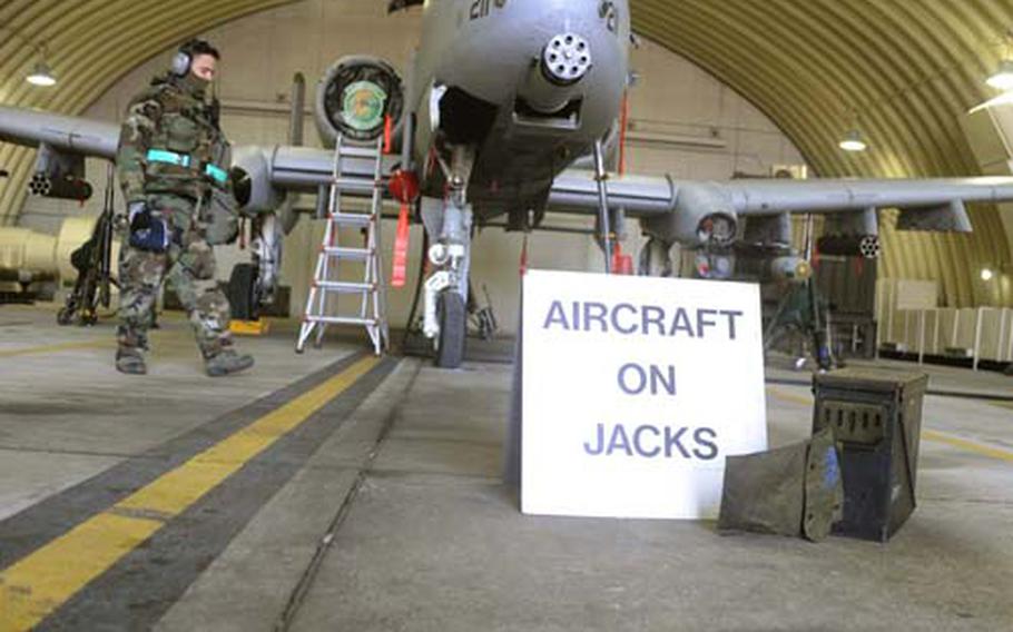 Air Force Staff Sgt. Randal Ogozalek checks the jacks under an A-10 Thunderbolt II attack plane.