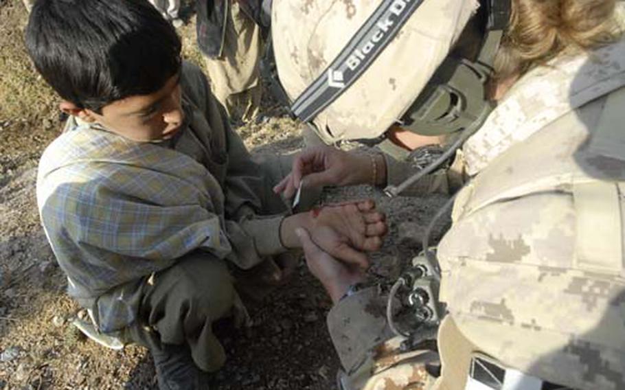 A Canadian medic treats an Afghan boy in Kandahar as part of an effort to develop a better rapport with the residents of the Taliban stronghold.