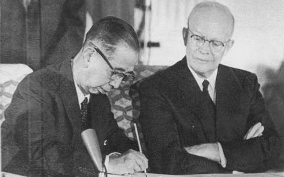 Jan. 19, 1960 Japan Prime Minister Nobusuke Kishi signs the U.S.-Japan military alliance pact on Jan. 19, 1960 with U.S. President Dwight D. Eisenhower looking on. The 50th anniversary of the signing is Tuesday, but the alliance has been strained in recent months over a controversy about basing U.S. Marine aviation units on Okinawa. treaty with President Eisenhpwer looking on.