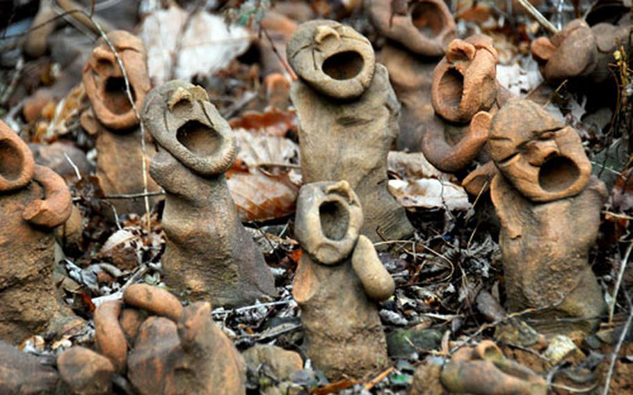 Dozens of small, clay figures are positioned near the entrance to a cave where hundreds of Koreans died during a 1951 U.S. air strike.