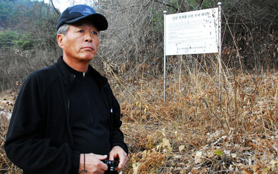 Cho Byung-gyu stands at the edge of a wooded area that is the mass grave for 172 unidentified victims of a 1951 U.S. air raid on a tiny South Korean village. Many among the 360 who died were refugees, and entire families were killed during the attack, making it impossible to identify them. Each grave is marked with a stone and a number assigned to them.
