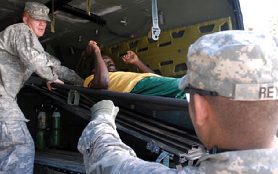 Soldiers unload an injured Haitian man from an Army ambulance Thursday to evacuate him to the USNS Comfort.
