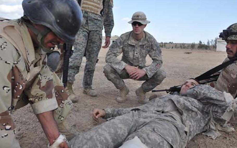 Sgt. William Winstead watches as soldiers with Iraq&#39;s 1st Army Division practice stanching wounds with bandages applying tourniquets during a combat first aid class.