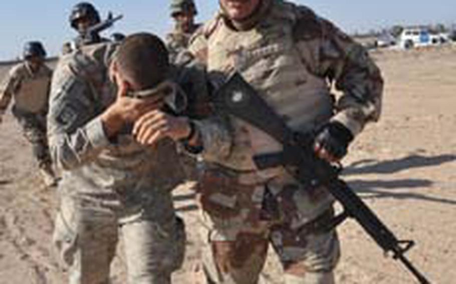 Iraqi soldier Javod Waesm helps Pfc. Steven McNally to safety during a mock bombing, where he was "blinded" by shrapnel.
