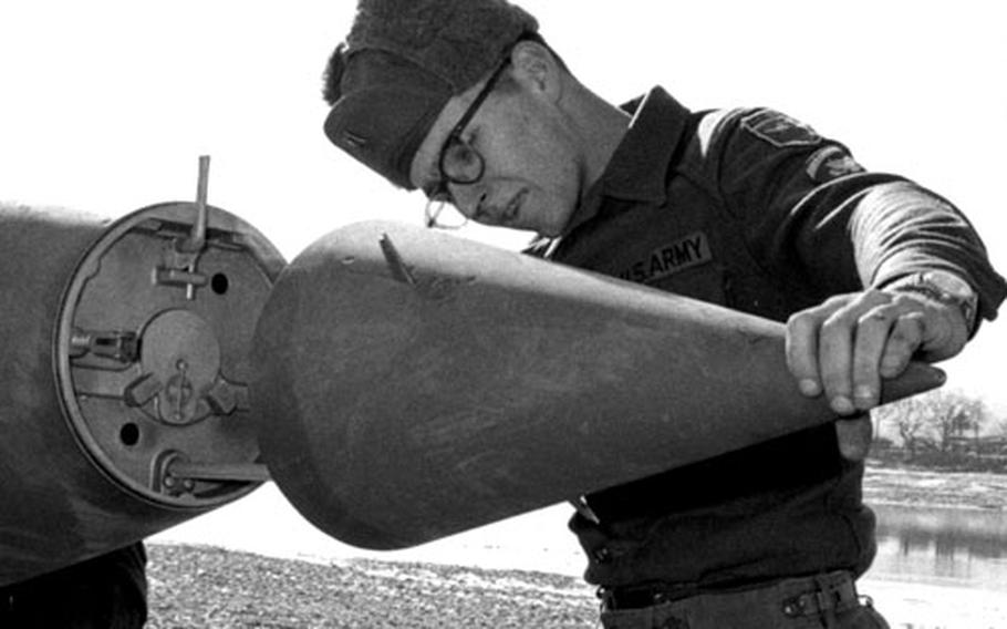 Spc. 5 Levi A. Bragdon, a senior assembly specialist, prepares the nose cone of an Honest John missile for launch in South Korea in January, 1969.