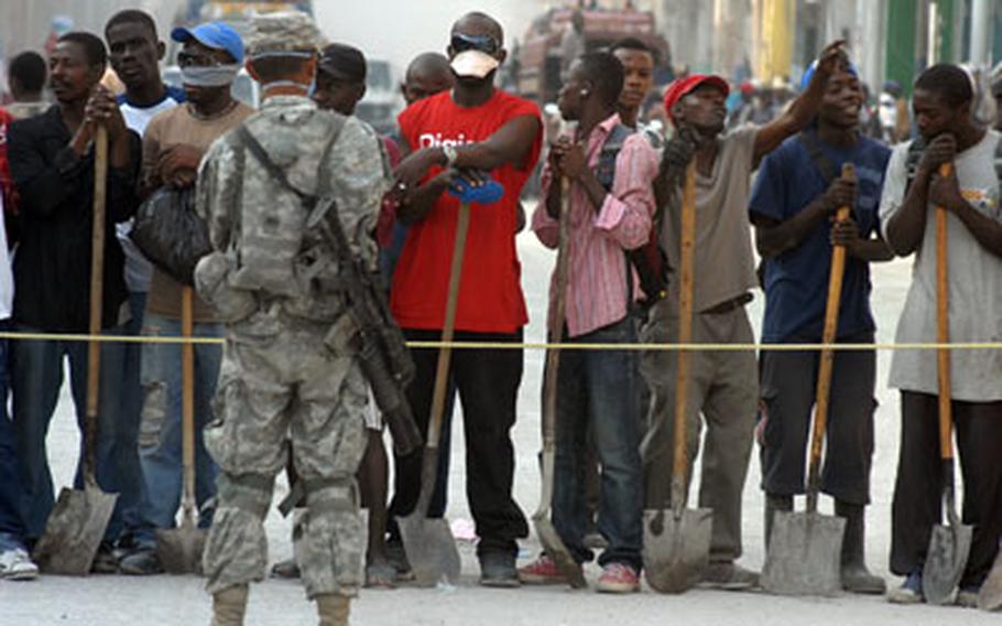 Haitians waiting for jobs shoveling rubble from the streets in Port-au-Prince enjoy pop music played by U.S. soldiers Feb. 25.