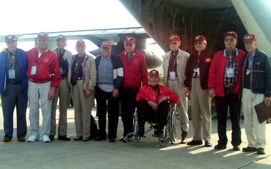 The veterans pose for a photo in front of the plane they were hoping would be their ride to Iwo Jima.