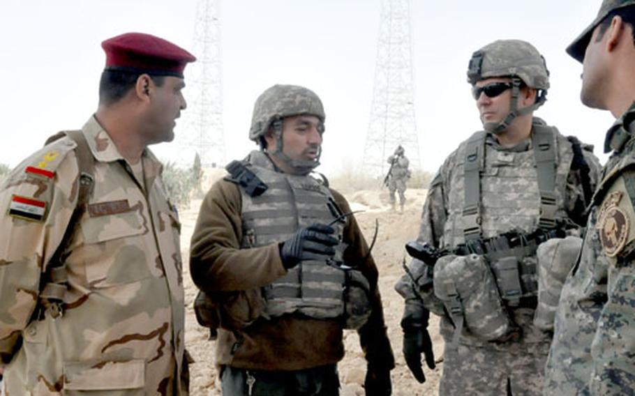 Col. Mark Stammer, right, talks about security for this Sunday’s elections with Lt. Col. Ali Muhamad Kadhun al-Saadi, left, commander of the Iraqi army in the towns of Rawah and Anah.
