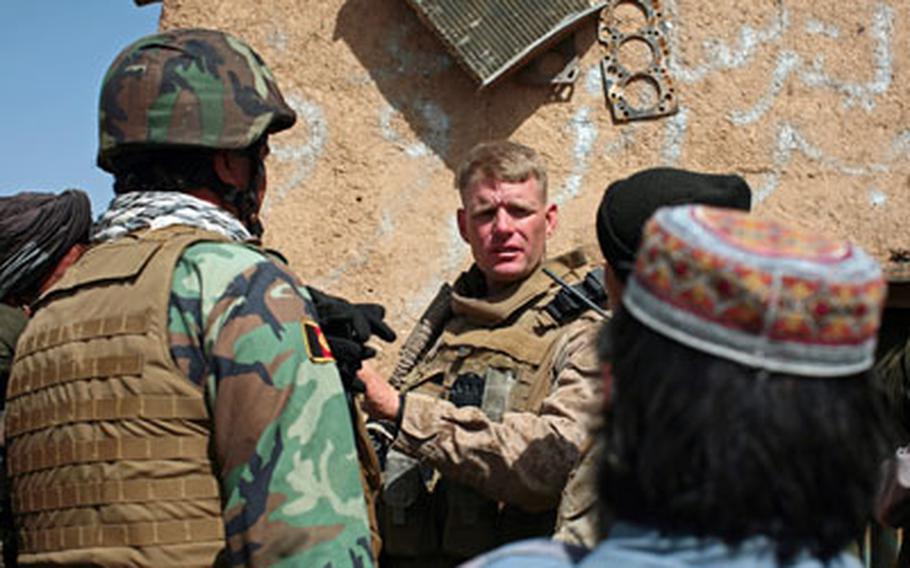 Lt. Col. Brian Christmas, commander of 3rd Battalion, 6th Marine Regiment, listens to the concerns of a local villager through a translator in the village of Marjah, Afghanistan.