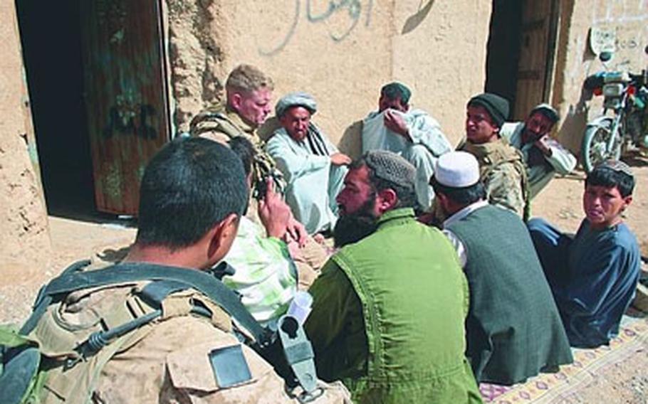 Lt. Col. Brian Christmas, commander of 3rd Battalion, 6th Marine Regiment, meets Friday with men in Marjah, Afghanistan, to discuss reopening a school there. Villagers want a new school but fear the Taliban will punish them for cooperating with U.S. forces.