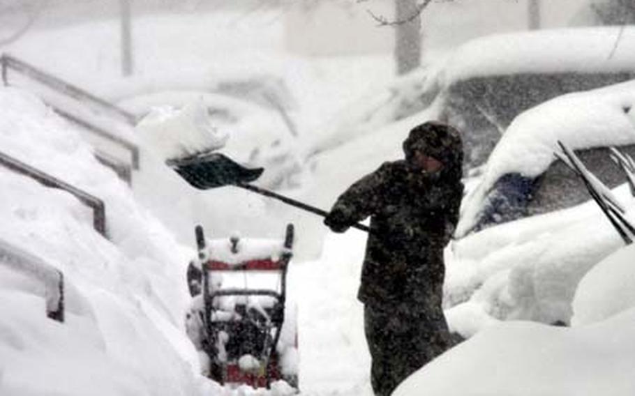 A housing area resident digs out his sidewalk Wednesday during a blizzard that hit Misawa Air Base, Japan.