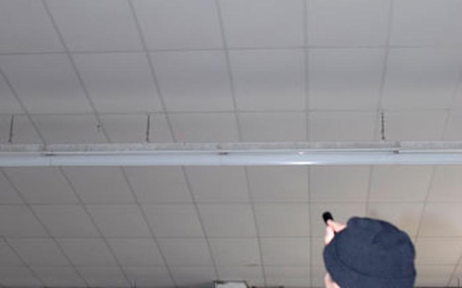 Gordon Adam, an environmental technician with U.S. Army Garrison Wiesbaden’s Directorate of Public Works, points to a spot in the ceiling inside Building 6217 at McCully Barracks in Wackernheim, Germany. Adam said the hole, along with the droppings beneath it, are evidence that barn owls are living inside the run down facility.