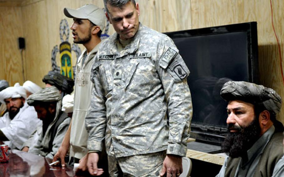 Lt. Col. Matt McFarlane glances at Ghulam Muhammad, the head of the Afghan Provincial Protection Force, during a meeting of Wardak province elders. McFarlane, the top U.S. commander in Wardak, credits the local militias overseen by Muhammad with improvements in security.