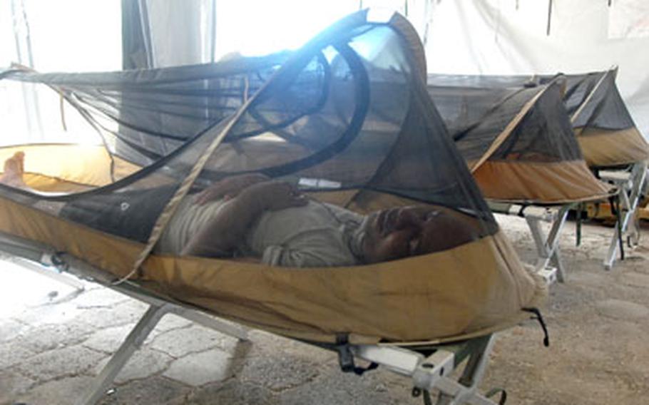 Service members in Haiti sleep under mosquito netting that helps protect them from malaria carried by the insects.