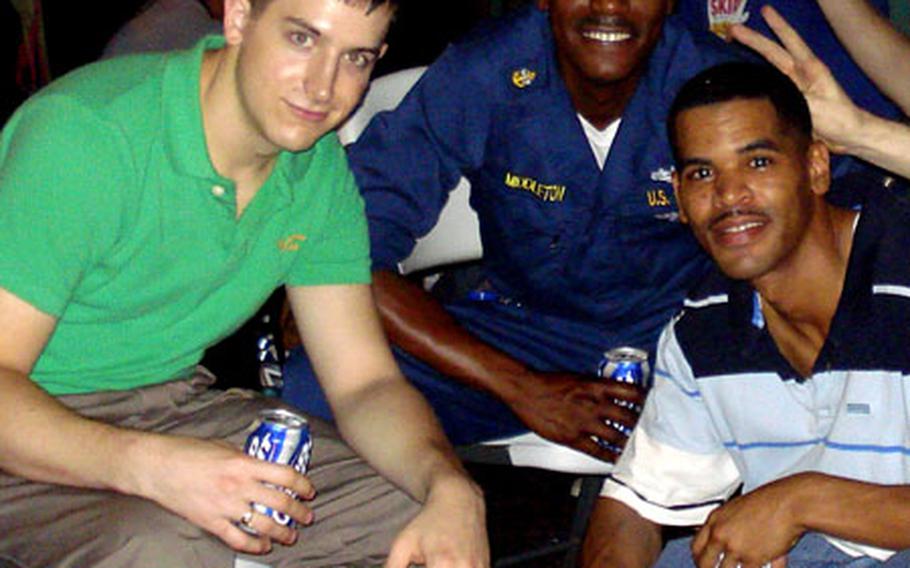 Petty Officer 1st Class Patrick Brendan Mack, left, and Seaman Lonnie Davis Jr. with friends.