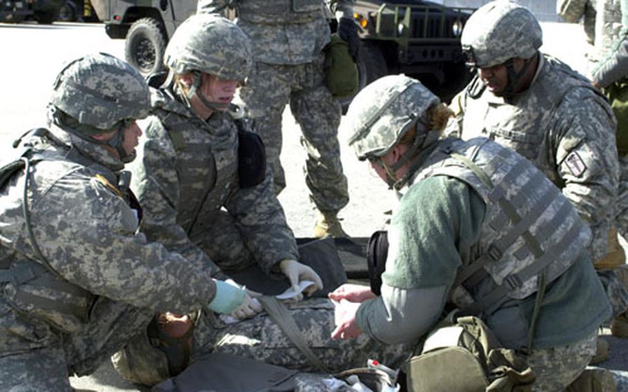 Medics simulate treatment of battlefield injuries Tuesday during an exercise that brought some 200 medical personnel from seven companies to Camp Stanley in South Korea. During the exercise, the medical units practiced procedures that would be used in the event hostilities resumed on the peninsula.
