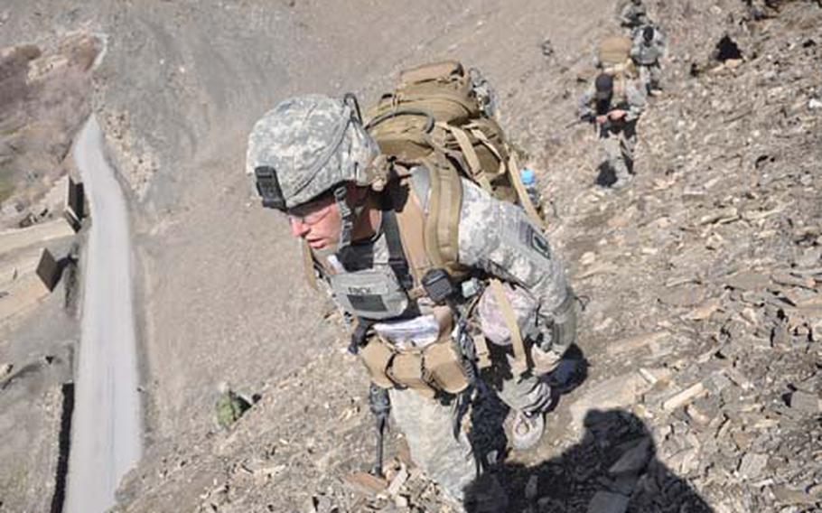 First Lt. Michael Finch scales a steep hillside during a patrol, leading his platoon from ridgeline to ridgeline to avoid booby traps in the farmland below.