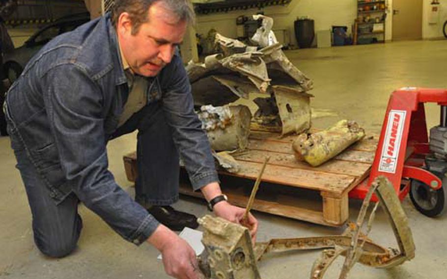 Weber shows off the mangled gun shield and mount. The plane was shot down by German anti-aircraft fire Feb. 14, 1945.