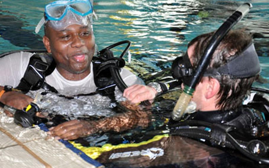 Staff Sgt. Derrick McClam jokes with his instructor after struggling to keep water out of his mask during a scuba diving class for wounded soldiers in Bamberg, Germany.