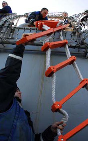 Sailors on the USS Curtis Wilbur on Saturday drop a ladder to passengers waiting below.