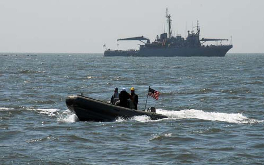 U.S. Navy personnel in a Rigid Inflatable Boat check the waters near a South Korean salvage ship, in the background, Saturday at the site of the wreckage of the South Korea patrol ship Cheonan, which sank on March 26 after an explosion.