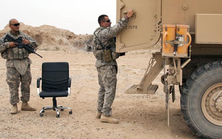 U.S. soldiers prepare to load a favorite desk chair into the back of a Mine Resistant Ambush Protected vehicle before departing Forward Operating Base Summerall near Beiji, Iraq.