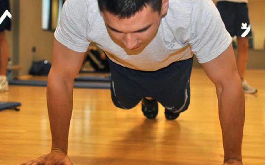 Senior Airman Anthony Enomoto does push-ups Friday at the Dragon Fitness Center at Aviano Air Base, Italy, during physical fitness testing. Enomoto and other members of the 31st Operations Support Squadron appeared to be doing well in the testing. But samples taken by the Air Force indicate that many airmen worldwide will have to improve their fitness to pass new standards that take effect July 1.