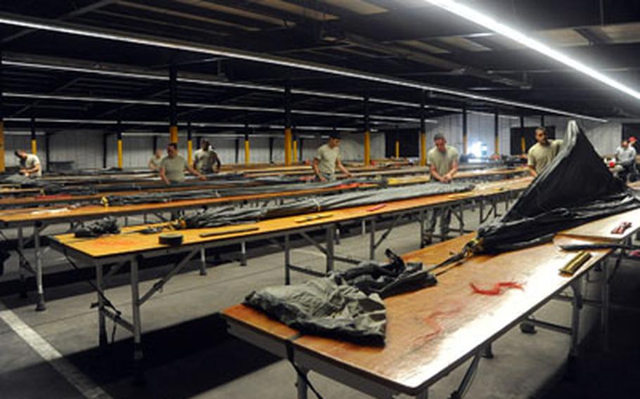 Parachute riggers with the 5th Quartermaster Detachment, 21st Theater Sustainment Command, pack new MC-6 parachutes at a warehouse on Rhine Ordnance Barracks in Kaiserslautern, Germany.