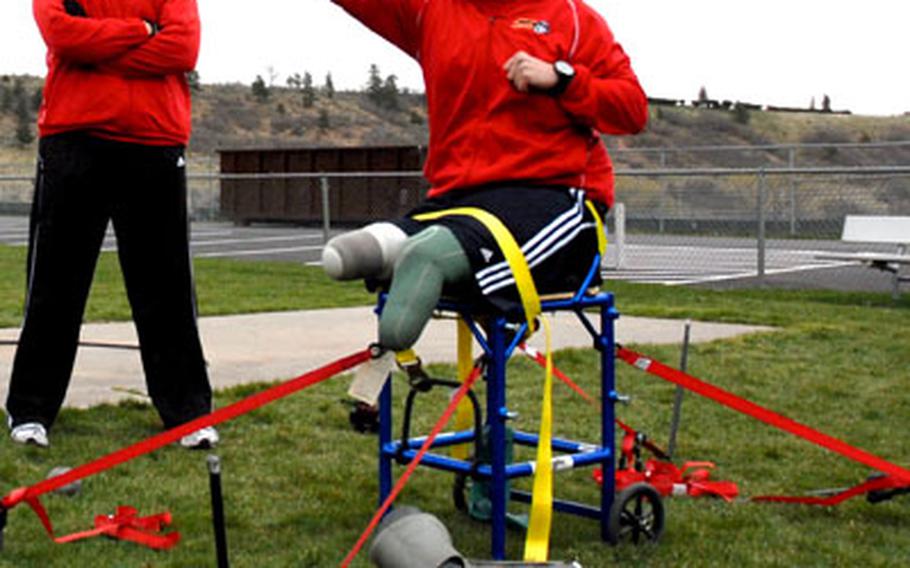 Former Marine Sgt. Bradley Walker practices shot put last week at the United States Air Force Academy in Colorado Springs, Colo., as his coach, also a former Marine sergeant, Eric Bildstein, looks on. Walker, a double-amputee, is also participating in hand cycling and sitting volleyball during the inaugural Warrior Games.