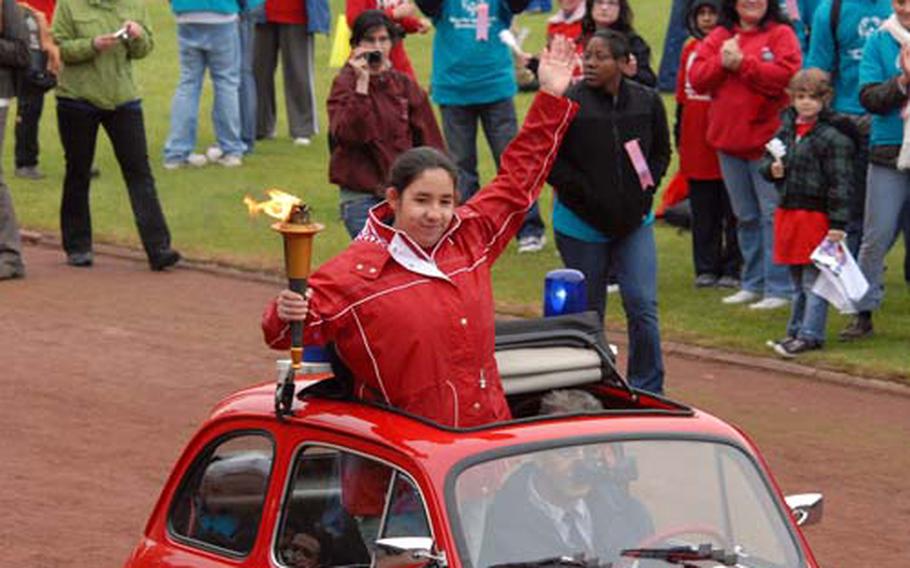 Brenda Guzman waves to the crown as she brings the Special Olympics torch into the stadium during the opening ceremony.