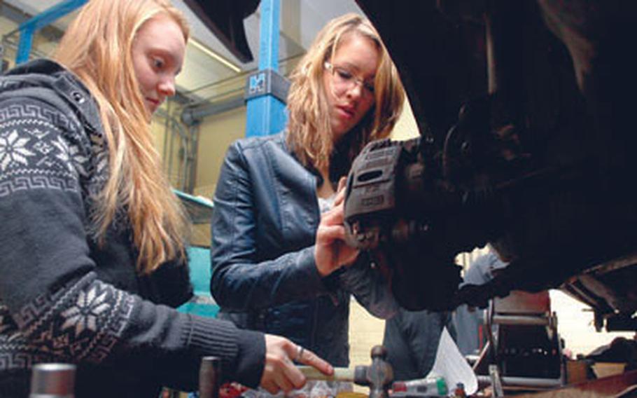 Micaela Young, left, and Elena Fritz reassemble a disk brake during auto tech class in January at Ramstein High School, Germany. Elena said she jumped at the opportunity to take the class because she&#39;d heard it will be discontinued next year.