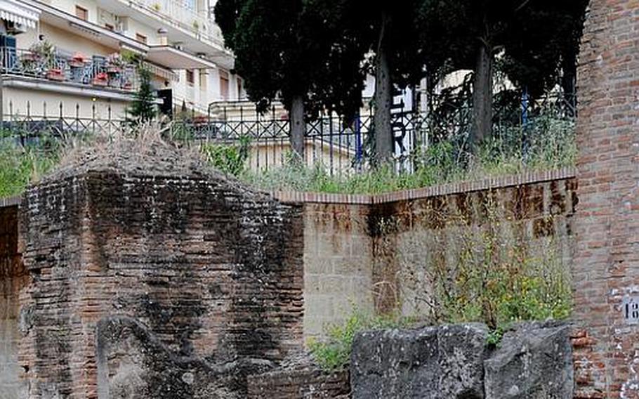 Modern-day apartment buildings line the roads just outside the fence surrounding the Flavio amphitheater, found in the center of Pozzuoli, Italy. The theater is thought to have been constructed during the era of emperor Vespasian, from 70 to 79.