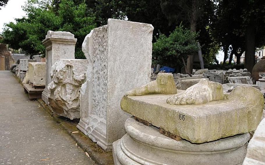 A row of inventoried columns, statues and headstones seem to haphazardly lie in at the entrance of the Flavio amphitheater - they have been cataloged but not organized for display.