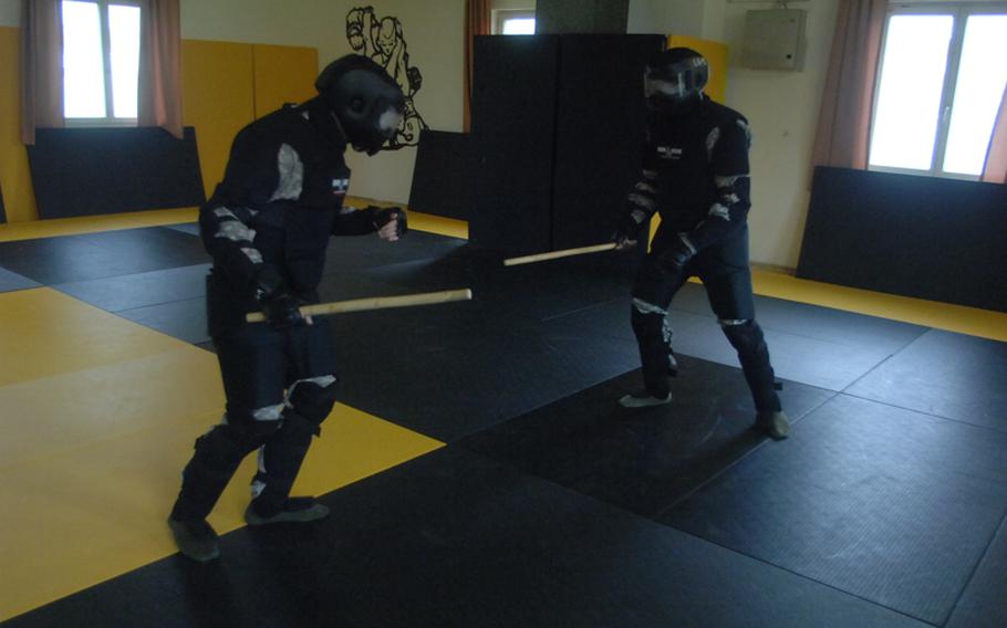 Pfc. Garrett Sorem, left, and Sgt. Brintun Jones, stick-fight during Level II Combatives training at the 7th Army Noncommissioned Officer Academy last week.