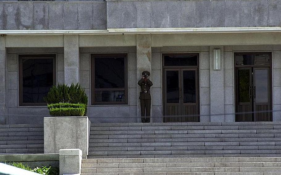 A North Korean soldier uses binoculars to keep an eye on a visiting group of teenagers on the South Korea side of the Demilitarized Zone on Wednesday. Tourists are still allowed at the Joint Security Area of the DMZ despite rising tensions between the two Koreas.