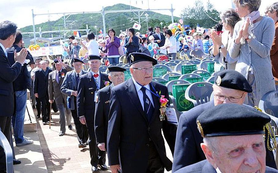 Veterans of the Battle of Chipyong-ni walk into a ceremony honoring them Wednesday for their part in the historic 1951 fight, as residents of the South Korean town and others applaud. The battle is recognized as a turning point in the Korean War.