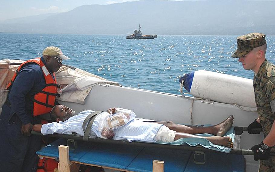 A Haitian boy with a broken leg, who had been treated on the USNS Comfort, awaits transport on a small boat from the hospital ship back to Haiti last Wednesday.