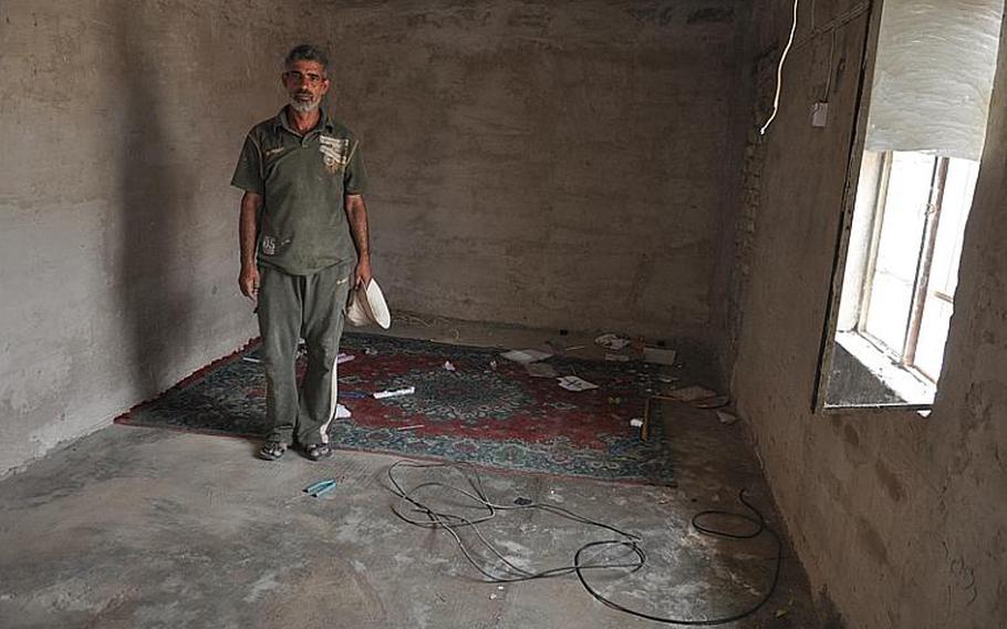 A resident of a squatters' camp in south Baghdad stands in his empty home on Tuesday. He lived with five other people in the one-room, cinder-block home and cleared out his possessions ahead of the government's steps to raze the camp. A day laborer, he says he can't afford rent and has no idea what he will do now.